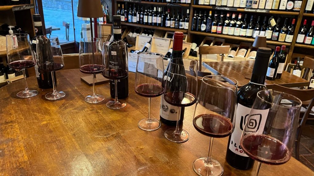 glasses and bottles of red wine lined up on a table