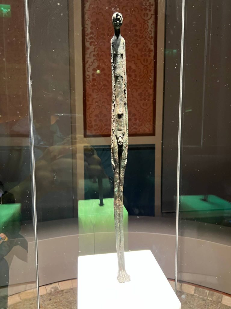 sculpture of a tall, thin boy from the etruscan civilization in the etruscan museum