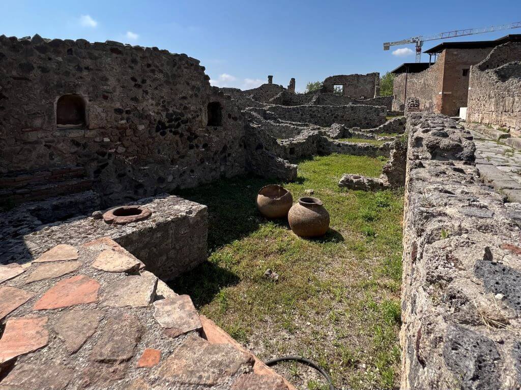Ruins Of A Small Home In Pompeii With Storage Urns On The Ground