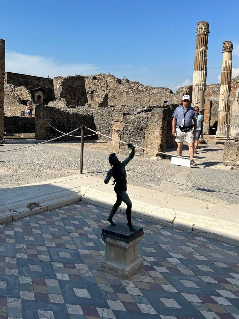 A Copy Of A Faun Statue In A Ruined Pompeii Courtyard