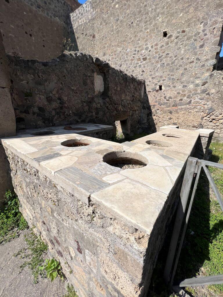 Several Containers In Marble Countertop That Were Used For Serving Food In Pompeii