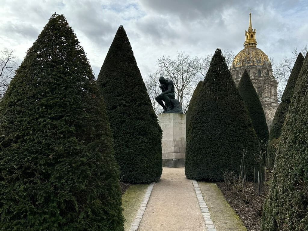 The Hotel Des Invalides Appearing Behind The Thinker At The Rodin Museum